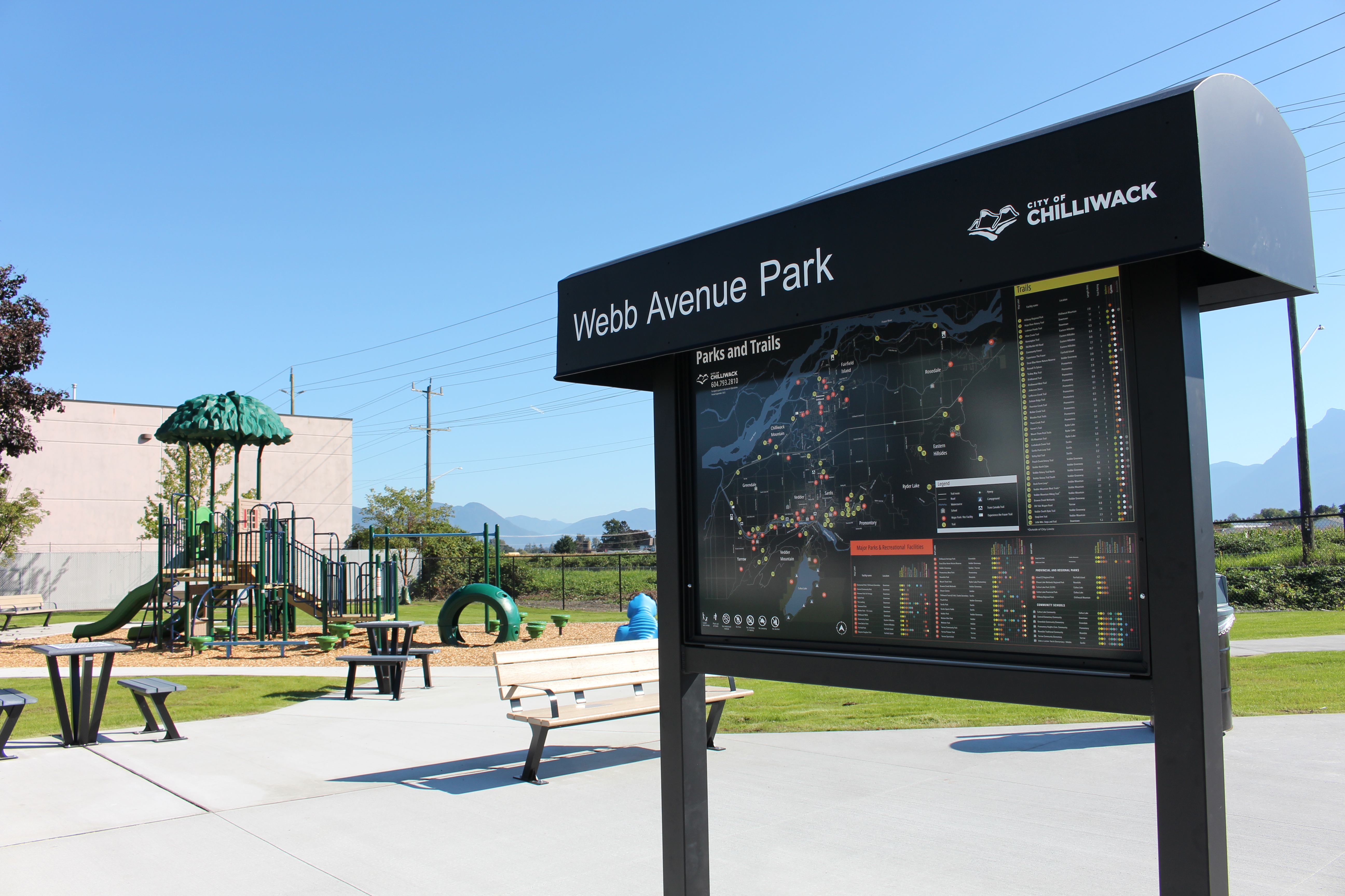 Webb Avenue Park signage in front of a playground.